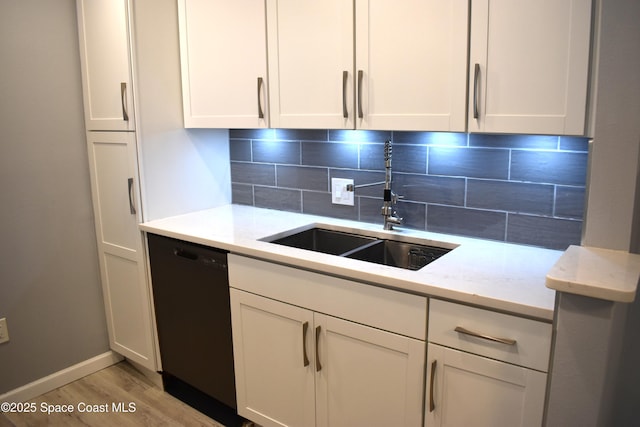 kitchen with white cabinetry, dishwasher, sink, backsplash, and light stone countertops