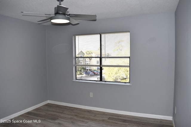 empty room featuring dark hardwood / wood-style floors, a textured ceiling, and ceiling fan