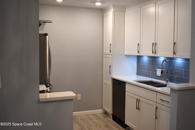 kitchen with sink, white cabinetry, tasteful backsplash, stainless steel refrigerator, and dishwasher