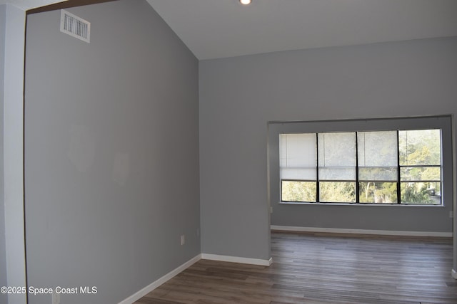 empty room with lofted ceiling and dark hardwood / wood-style flooring