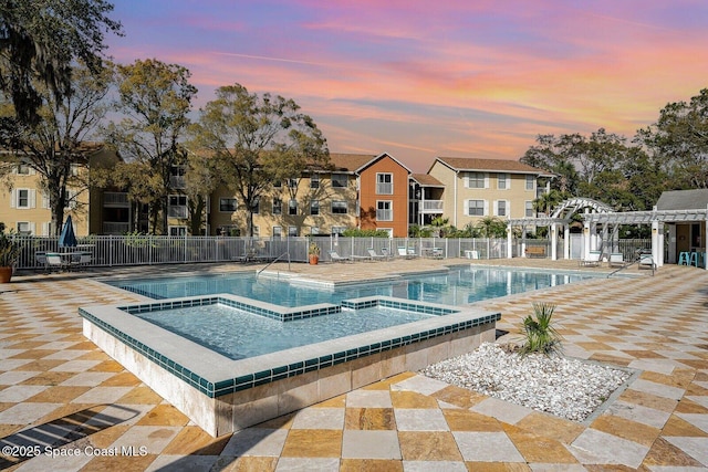 pool at dusk with a pergola, a hot tub, and a patio