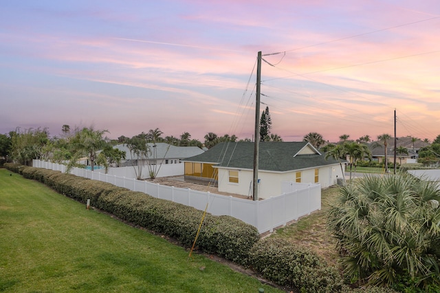 property exterior at dusk with a yard