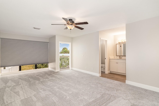 unfurnished bedroom featuring connected bathroom, access to exterior, ceiling fan, light carpet, and sink