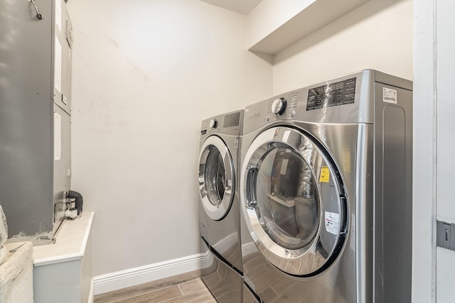 clothes washing area featuring light hardwood / wood-style flooring and washer and clothes dryer