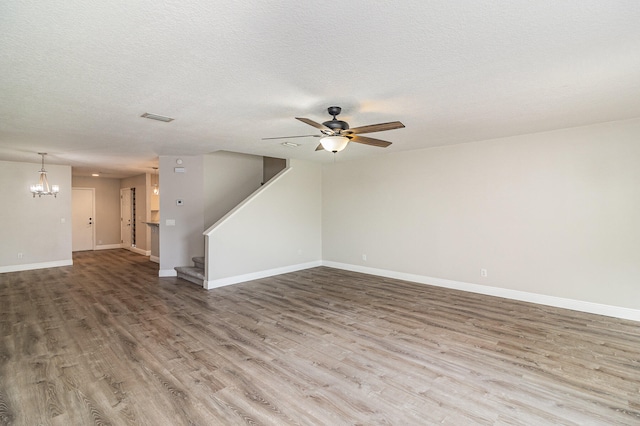 spare room featuring hardwood / wood-style floors, a textured ceiling, and ceiling fan with notable chandelier