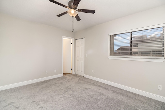 empty room featuring light colored carpet and ceiling fan