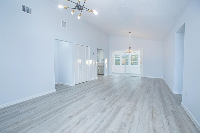 unfurnished living room with light hardwood / wood-style flooring, high vaulted ceiling, a chandelier, and a textured ceiling