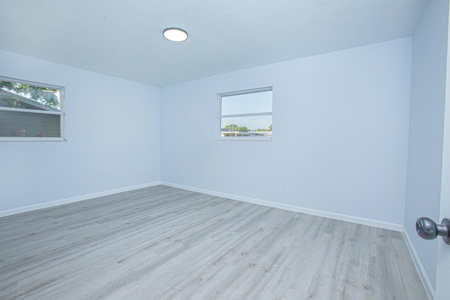 spare room with light hardwood / wood-style flooring and a textured ceiling