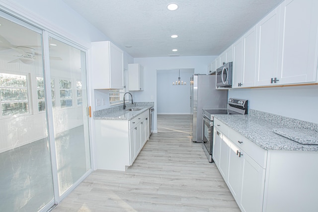 kitchen featuring white cabinets, appliances with stainless steel finishes, and light hardwood / wood-style floors