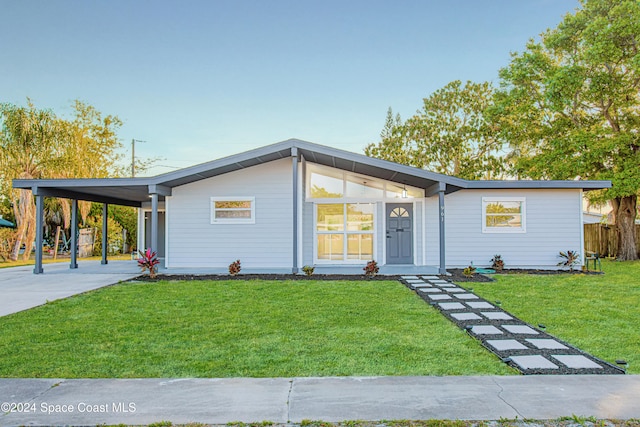 view of front of property featuring a front yard and a carport