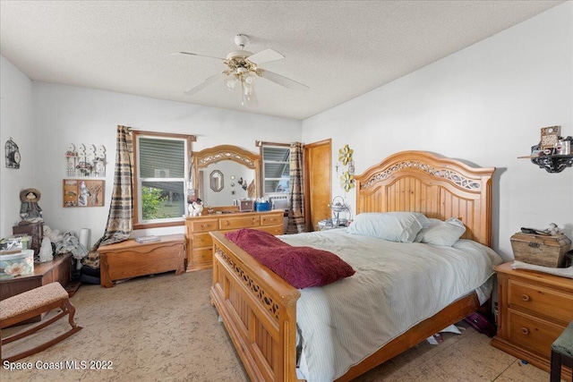 tiled bedroom featuring a textured ceiling and ceiling fan