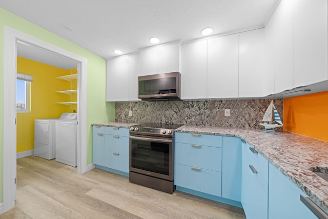 kitchen with light stone countertops, tasteful backsplash, stainless steel appliances, washer and clothes dryer, and white cabinets