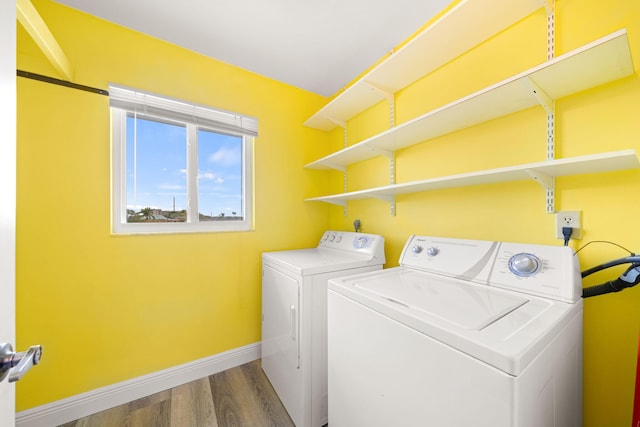 clothes washing area with washer and dryer and hardwood / wood-style floors