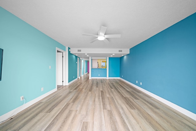 unfurnished living room with a textured ceiling, light hardwood / wood-style flooring, and ceiling fan