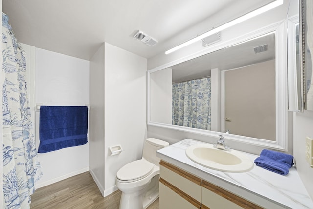 bathroom with hardwood / wood-style flooring, vanity, and toilet