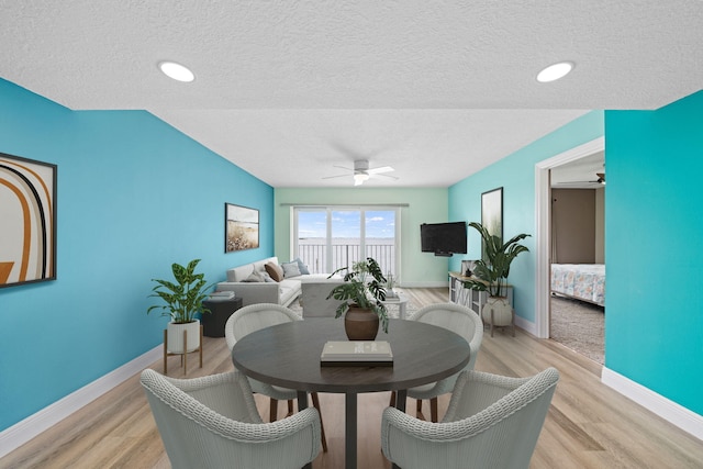 dining area with a textured ceiling, light hardwood / wood-style flooring, and ceiling fan