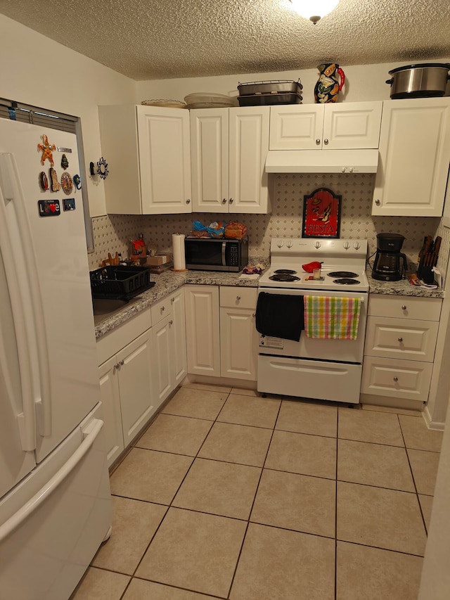 kitchen featuring light tile flooring, a textured ceiling, white appliances, and white cabinetry