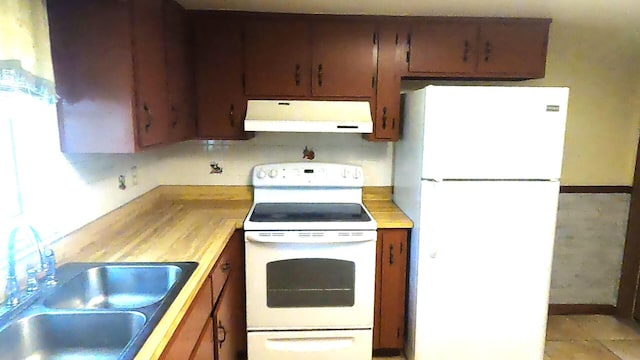 kitchen with white appliances, light tile flooring, sink, and exhaust hood