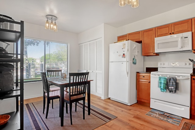 kitchen featuring white appliances, light hardwood / wood-style flooring, and an inviting chandelier