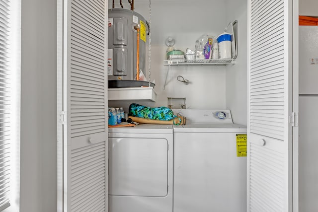 laundry area with hookup for a washing machine, electric water heater, and washer and dryer