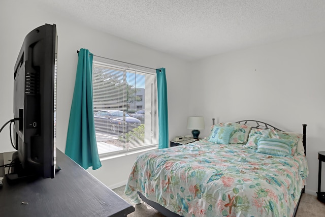 bedroom featuring multiple windows, a textured ceiling, and carpet floors