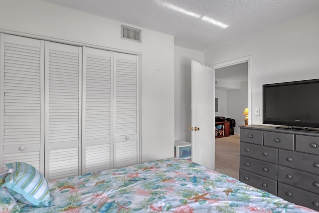 carpeted bedroom with a textured ceiling and a closet