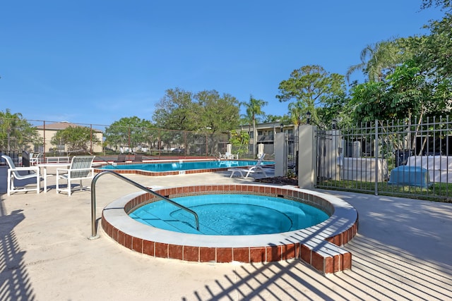 view of pool with a hot tub and a patio area