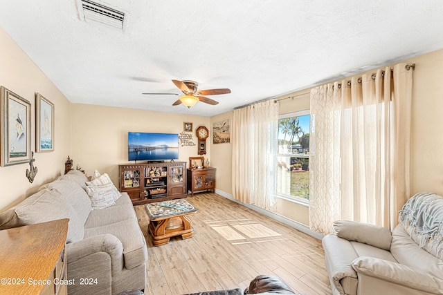 living room with ceiling fan, wood-type flooring, and a textured ceiling