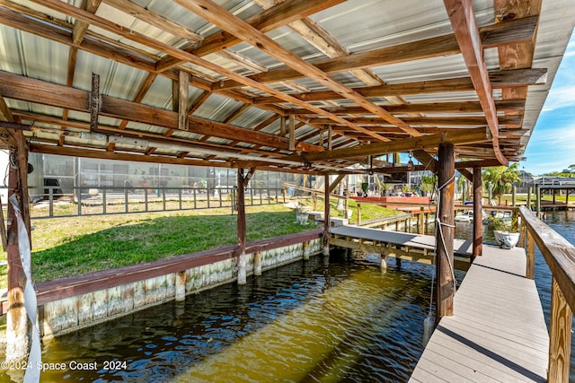 view of dock with a lawn and a water view