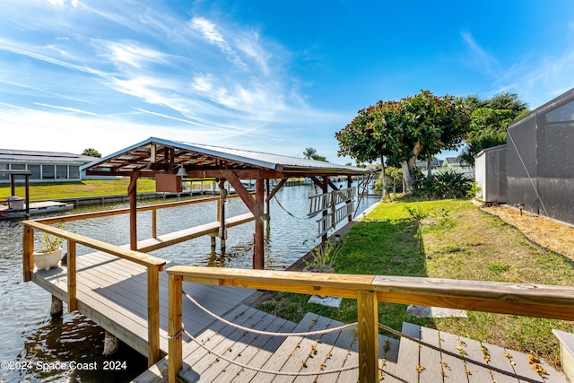 view of dock featuring a water view, glass enclosure, and a lawn