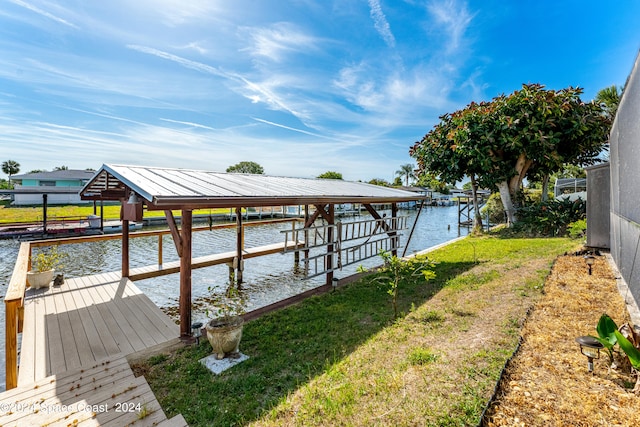 view of dock with a yard and a water view