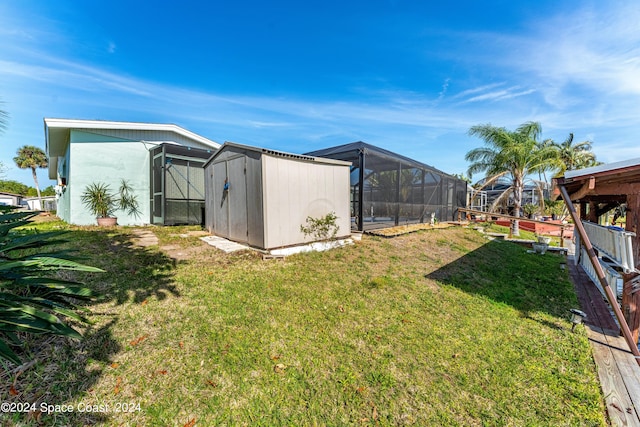 view of yard featuring glass enclosure and a storage shed