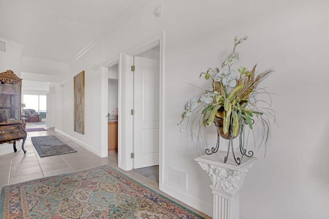 hallway featuring tile floors and ornamental molding