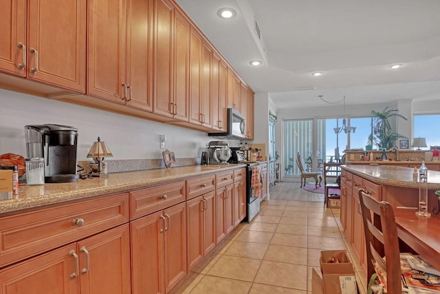 kitchen with black / electric stove, light stone counters, and light tile flooring