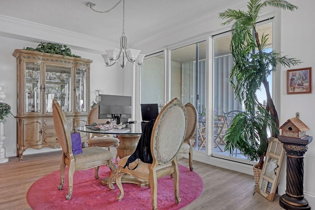 dining room with a notable chandelier, crown molding, light wood-type flooring, and plenty of natural light