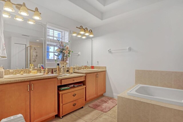 bathroom featuring double sink vanity, tile floors, and separate shower and tub