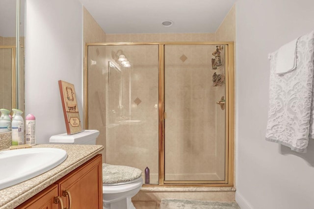 bathroom featuring toilet, large vanity, walk in shower, and tile flooring