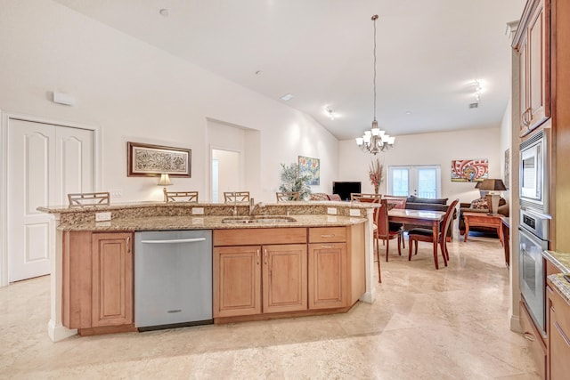 kitchen featuring appliances with stainless steel finishes, pendant lighting, lofted ceiling, a center island with sink, and sink