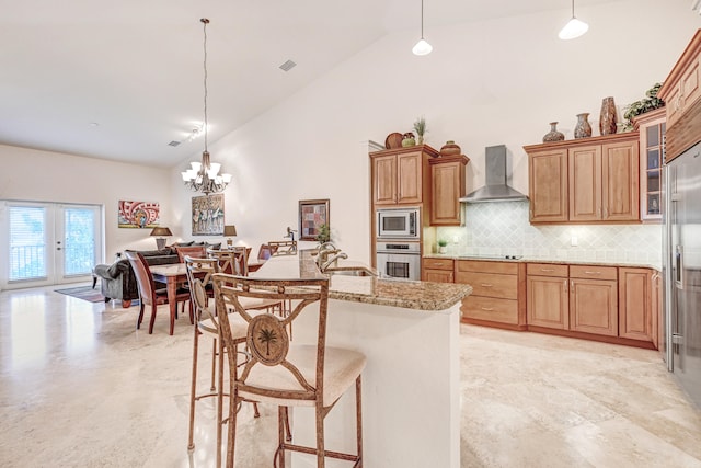 kitchen featuring pendant lighting, tasteful backsplash, wall chimney exhaust hood, high vaulted ceiling, and built in appliances