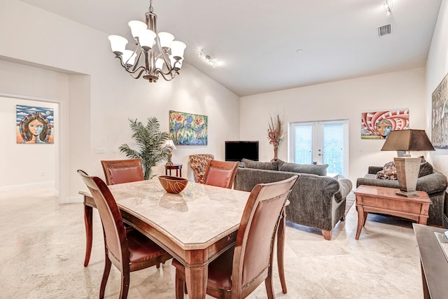 dining area featuring lofted ceiling, track lighting, a chandelier, and french doors