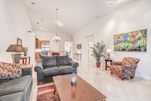 living room featuring high vaulted ceiling and a chandelier