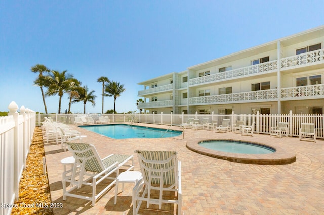 view of pool with a community hot tub and a patio