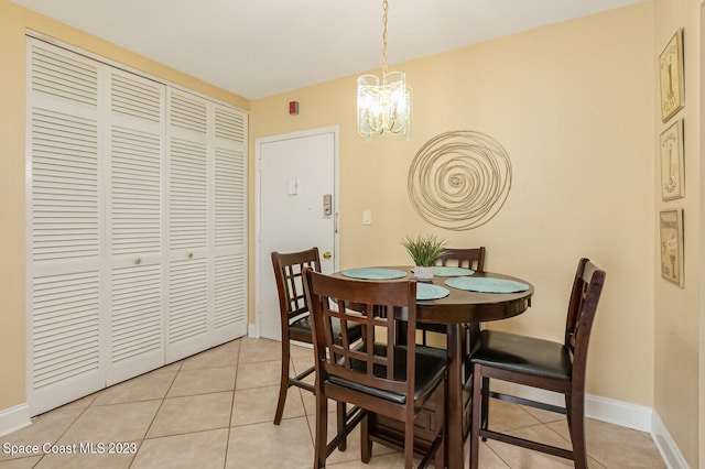 tiled dining room with a chandelier