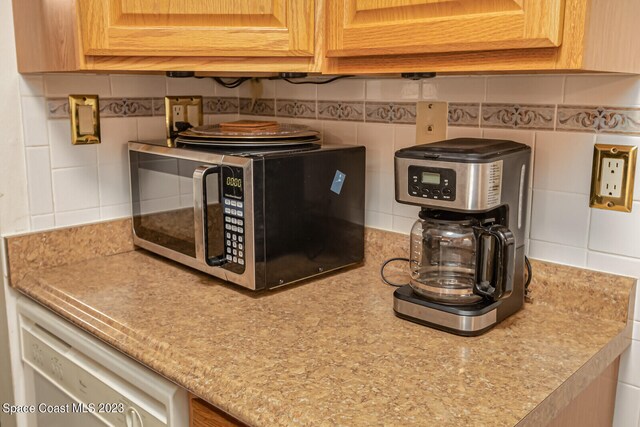 details featuring tasteful backsplash and dishwasher