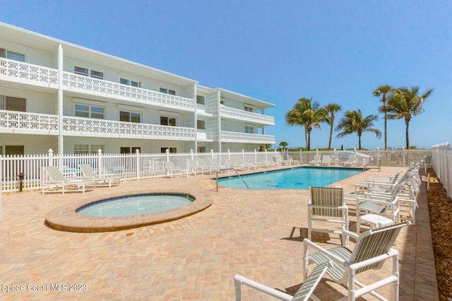 view of pool with a patio area and a hot tub