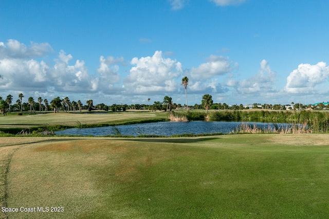 surrounding community with a water view and a lawn