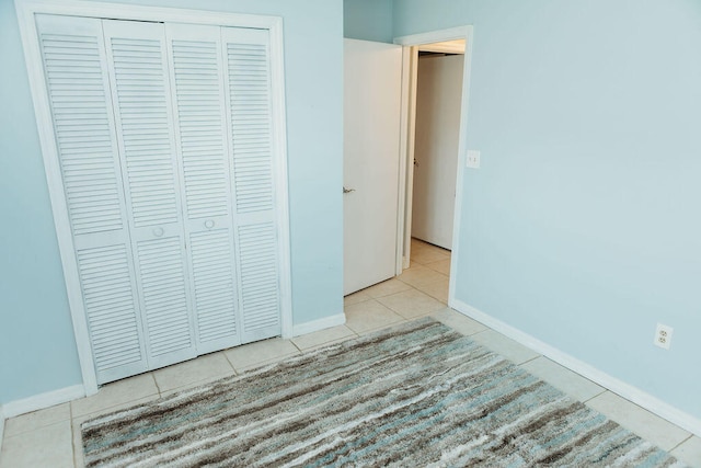 interior space featuring light tile flooring and a closet