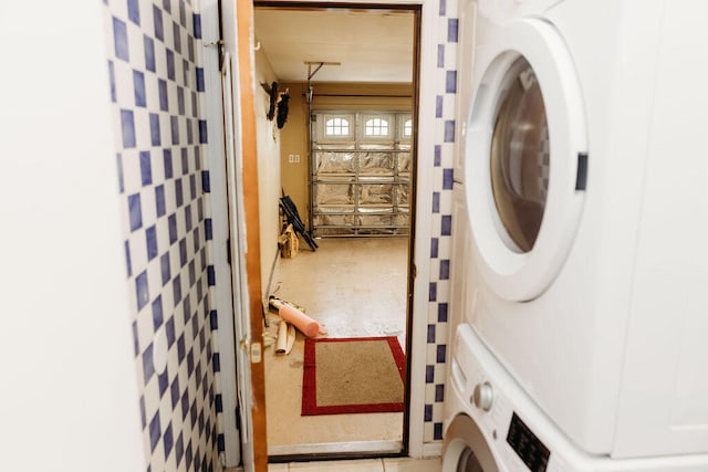 laundry room featuring stacked washer / drying machine