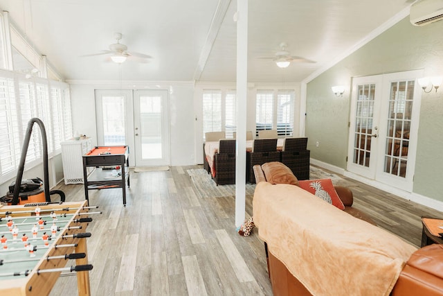 living room featuring an AC wall unit, french doors, light hardwood / wood-style flooring, ceiling fan, and ornamental molding