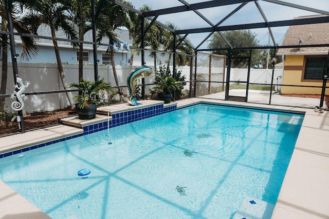 view of pool with glass enclosure and a patio area